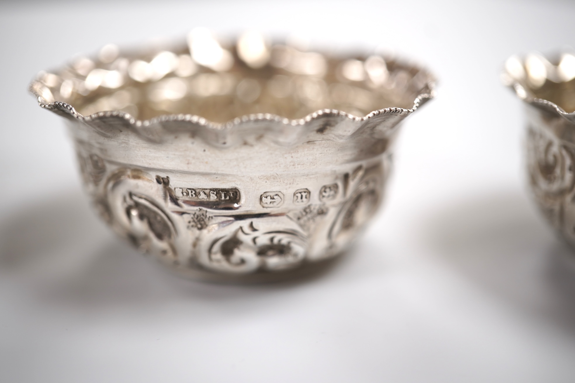 A group of small silver including a modern mounted wine coaster by M C Hersey & Son Ltd, diameter 12.6cm, a set of three George V nut dishes, one other silver nut dish, two pairs of salts including cauldron by William Hu